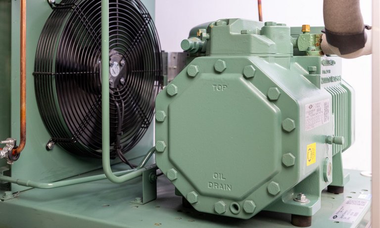 Foto eines Lüfters und Kompressors Foto eines Lüfters und Kompressors mit grün lackiertem Gehäuse aus einem Kältekreislauf.