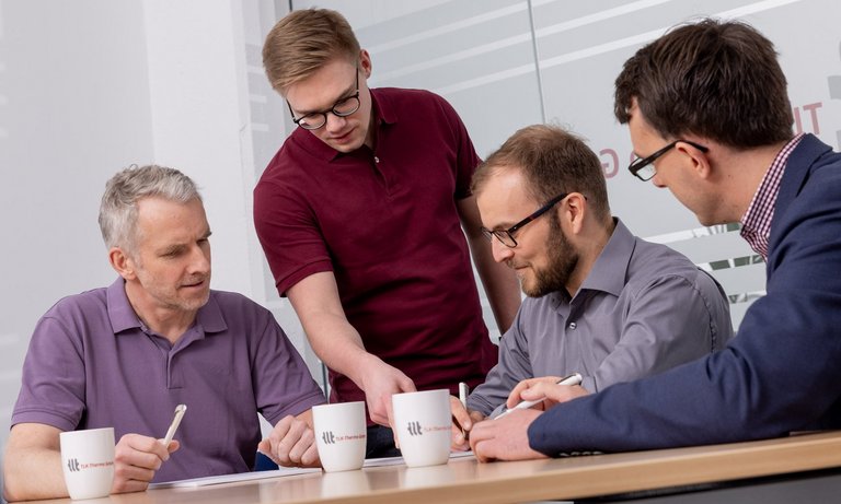 Vier Mitarbeiter in der Diskussion Vier Mitarbeiter diskutieren über verschiedene Themen in einem Besprechungsraum