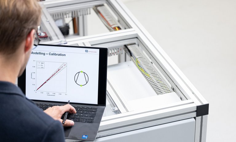 Ingenieur betrachtet Auswertung von Mess- und Simulationsdaten Ein Ingenieur kontrolliert eine Auswertung von Mess- und Simulationsdaten von einem Prüfstand und einem Simulationsmodell.