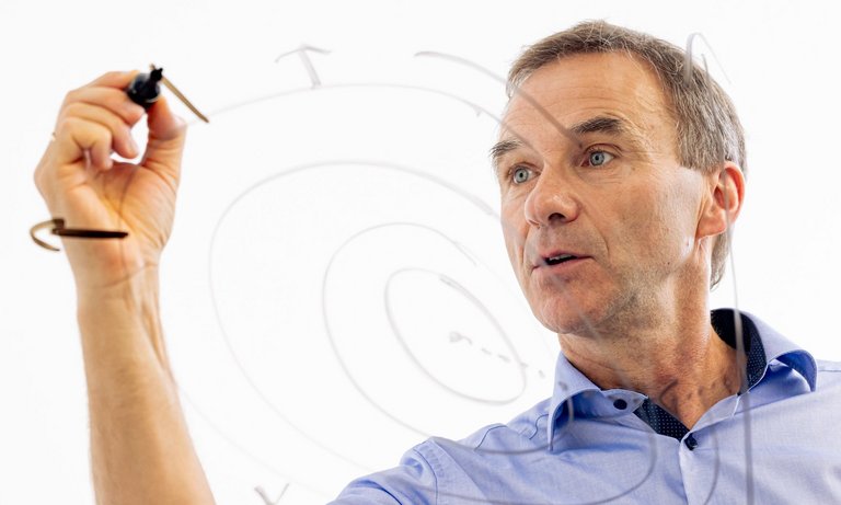 Ingenieur zeigt Optimierungsverfahren Ingenieur erklärt anhand einer Skizze ein Optimierungsverfahren.