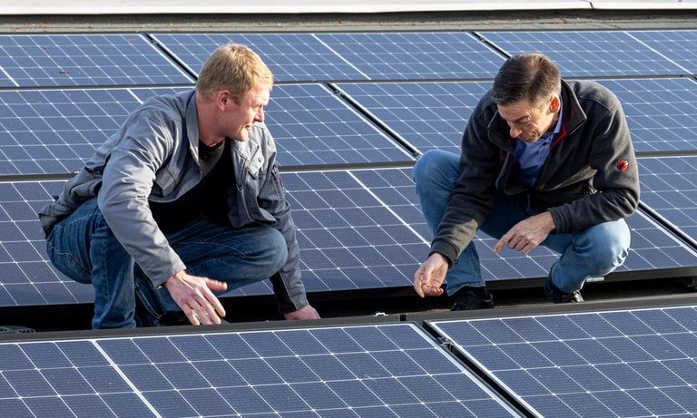 Two employees inspect the company's own photovoltaic system.
